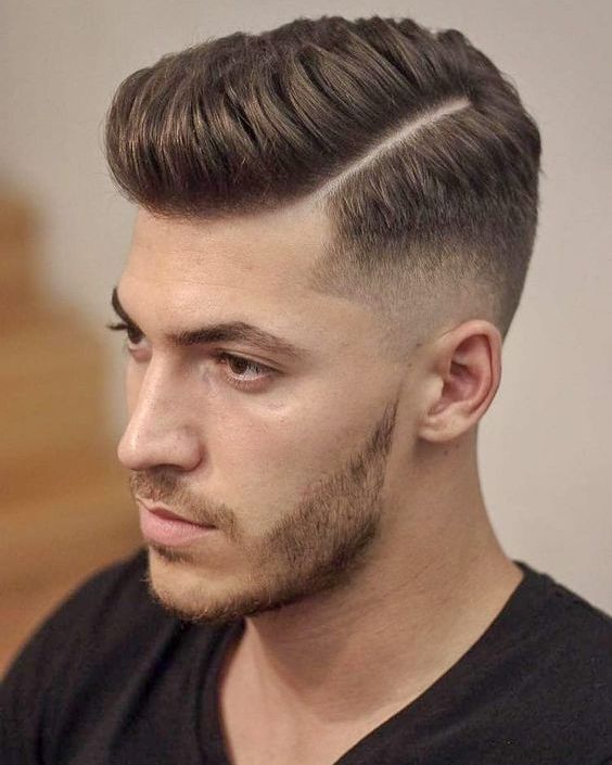 A man with a high & tight haircut, featuring closely cropped sides and back with a slightly longer patch on top for a sharp, masculine look.