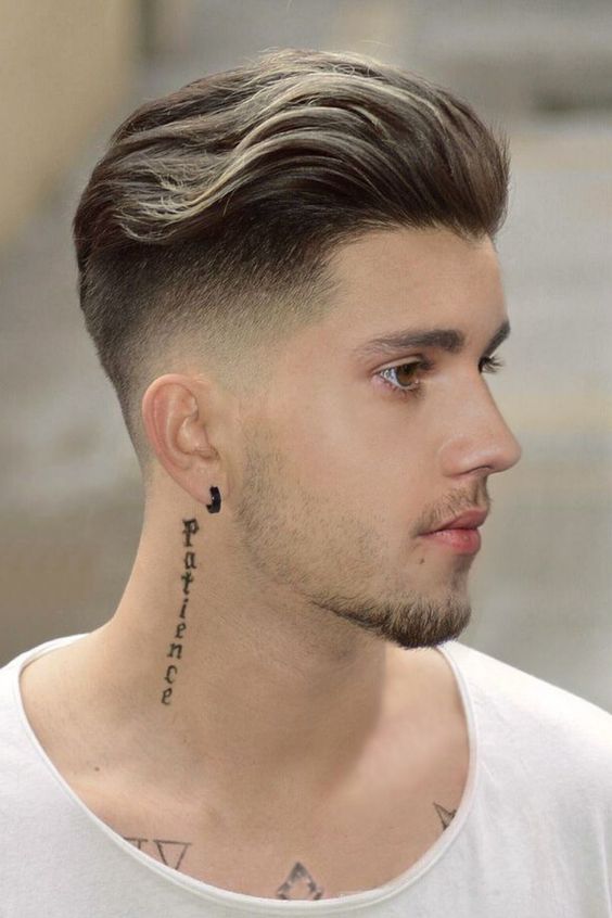 A man with a pompadour hairstyle, featuring longer hair on top brushed up and back to create height and shine.