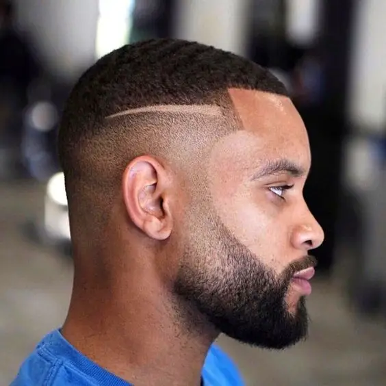 Black man with a beard fade and precise surgical line.