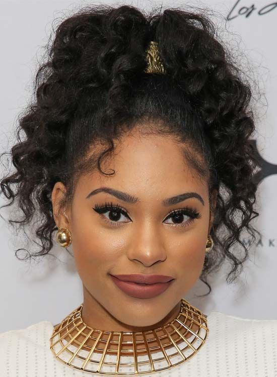 Vibrant curly ultra-high ponytail hairstyle with bouncy curls and a bold look.