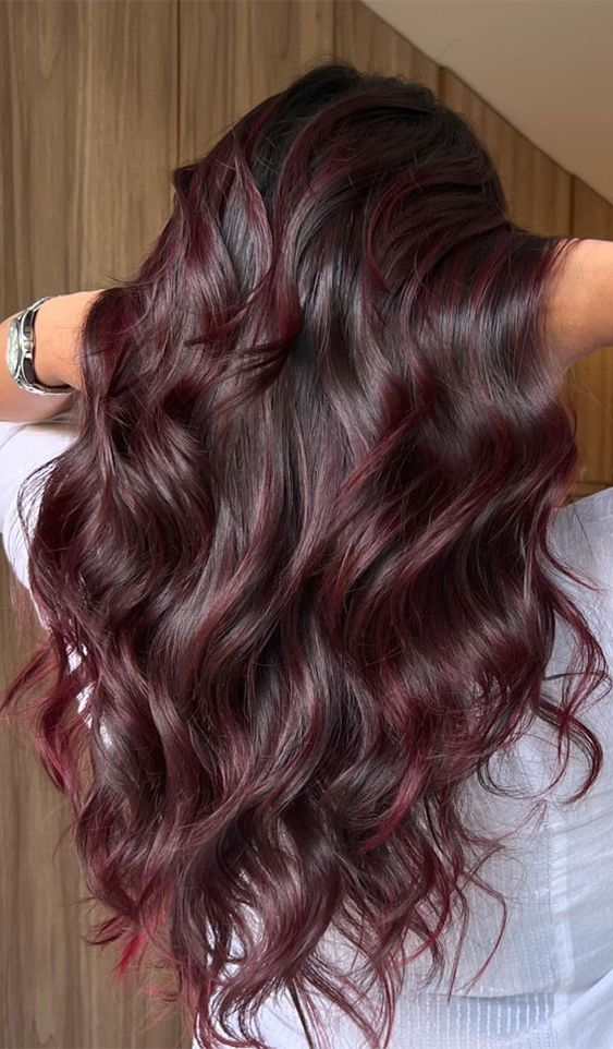 Enhance your style with rich burgundy hair color in balayage highlights. Long, low-maintenance layers keep your hair looking healthy and luxurious.