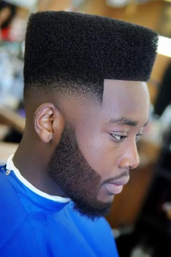 Black man with natural high top hairstyle.