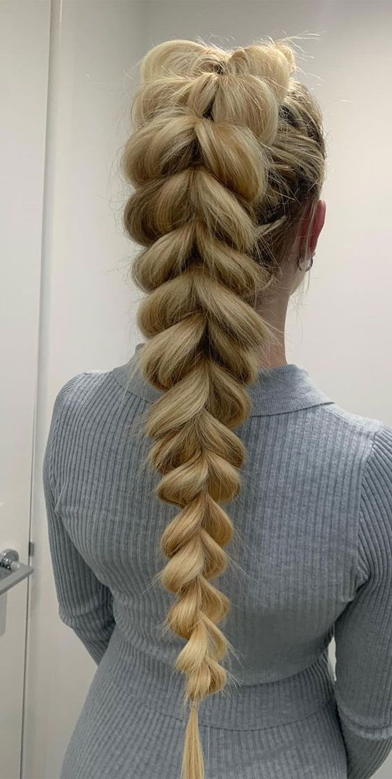 Intricate pull-through braid ponytail with a unique, woven appearance, blending braiding and ponytail elements