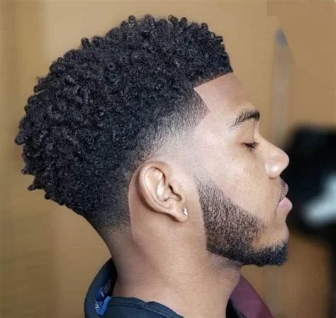 Black man with a tapered afro hairstyle.