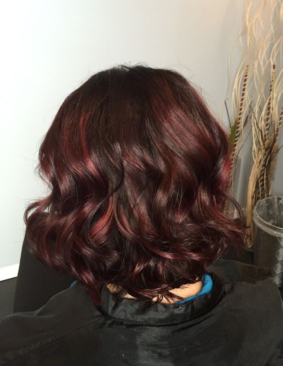 Combine brown and red shades for the perfect burgundy brown hair color. Wavy hair enhances the depth and dimension between the two colors.