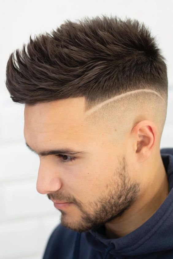 Man with a classic spiked Mohawk haircut with short sides and a tall, spiky center.