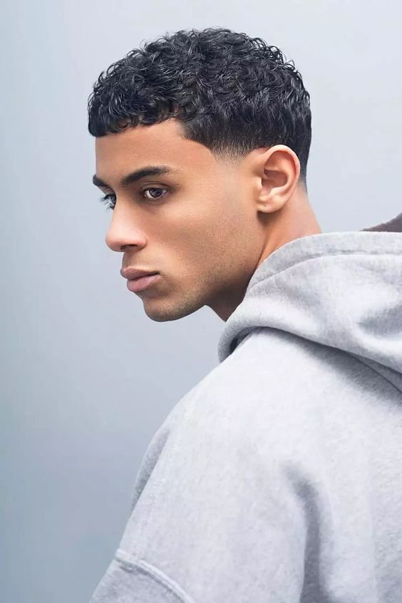 Curly crew cut for men, featuring short, textured curls with a clean, neat appearance.