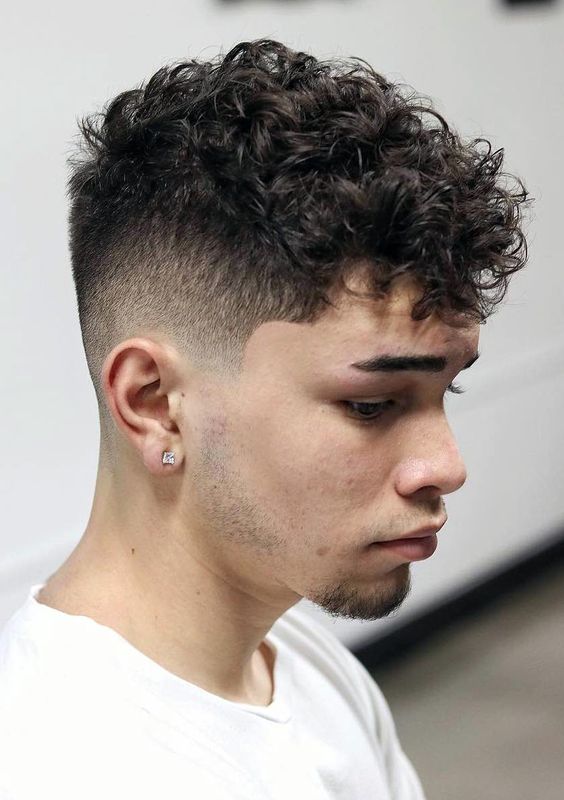 Curly undercut hairstyle for men, with shaved sides and longer curls on top.